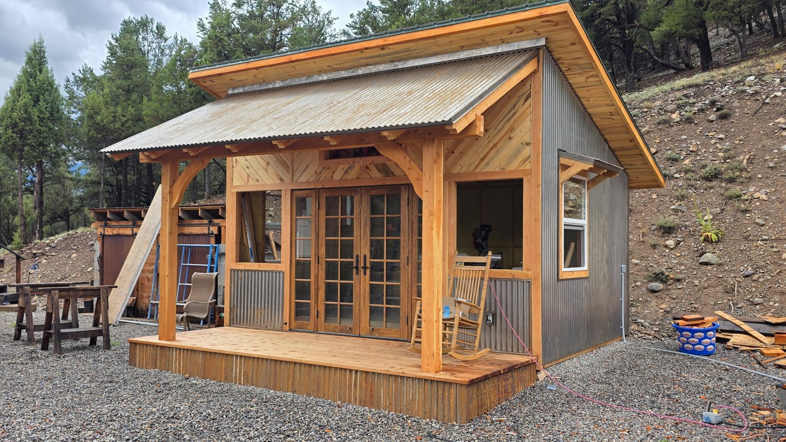 Shop with a timber porch: posts, knee braces and rafter tails